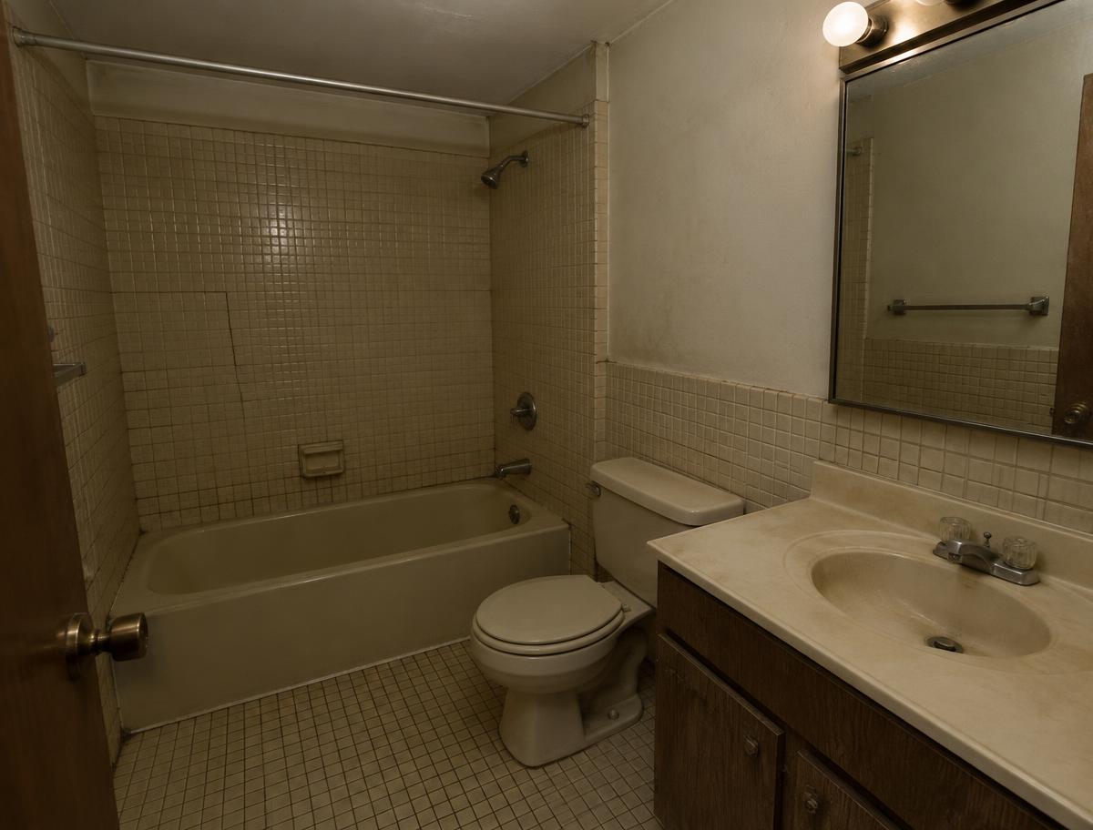 Dated bathroom with old square tile before renovation